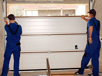New garage door being installed with its track and springs