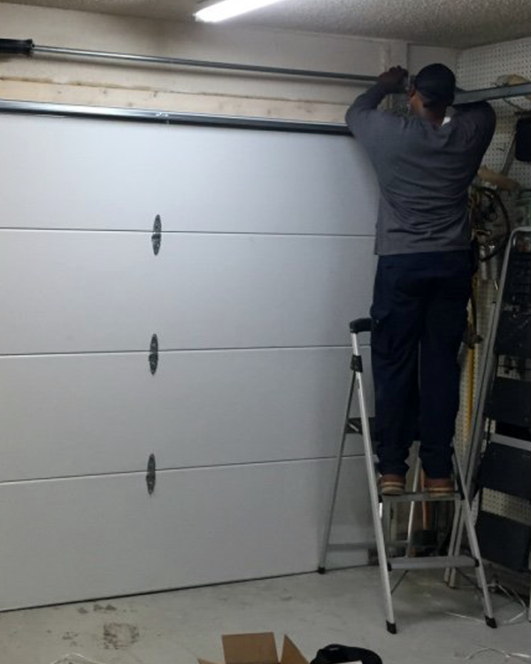 Technician repairing a Garage door section.