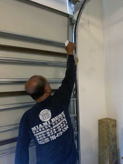 Technician repairing a garage door in Miami